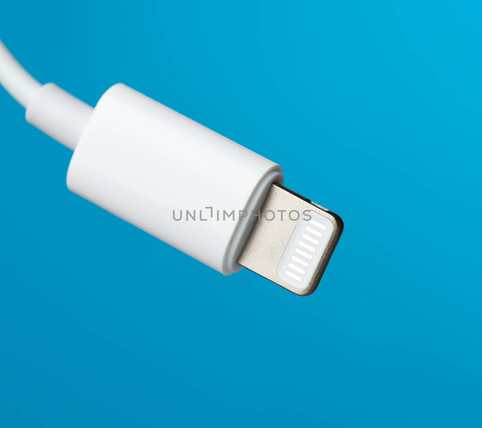 White lightning cable on a blue background, close up
