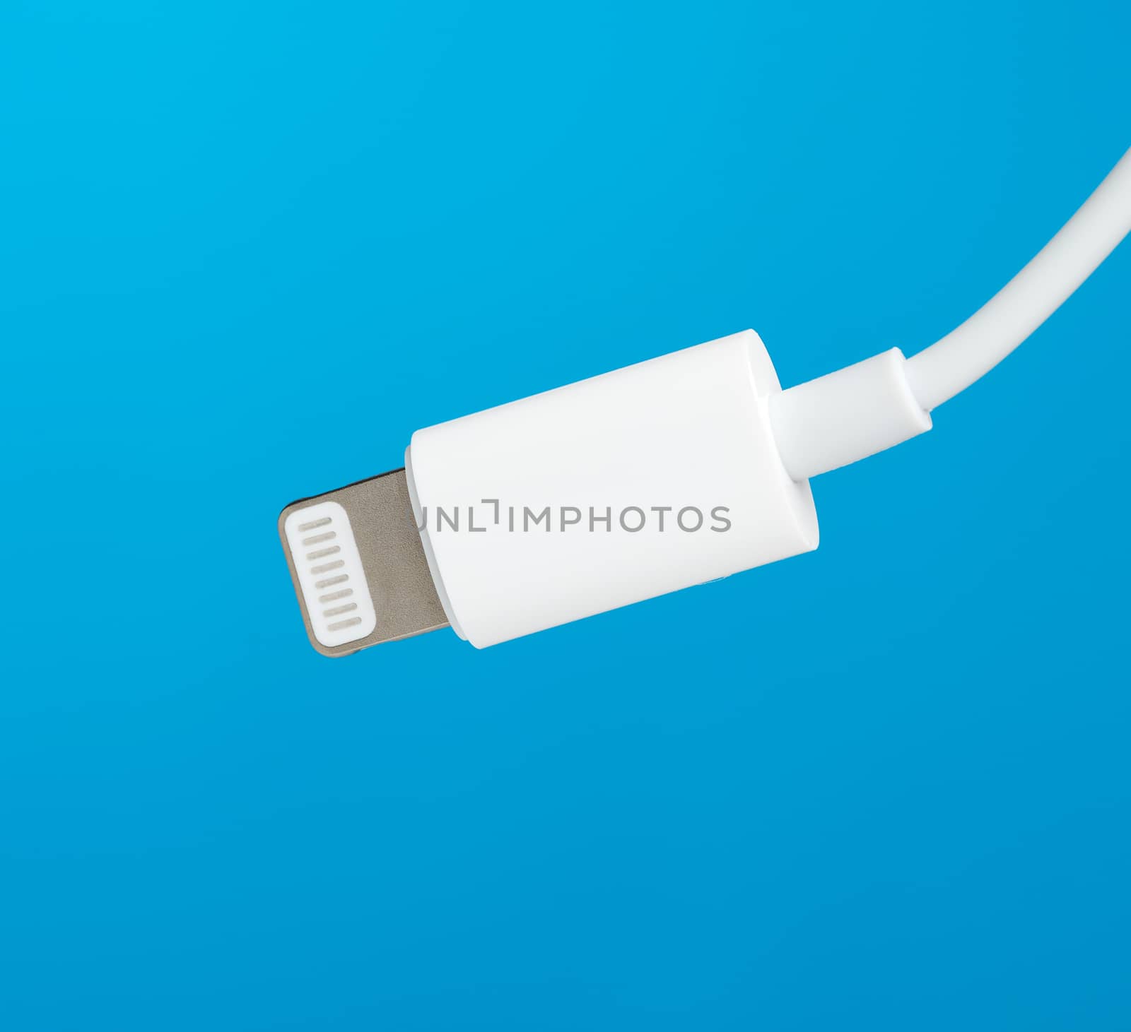 White lightning cable on a blue background, close up