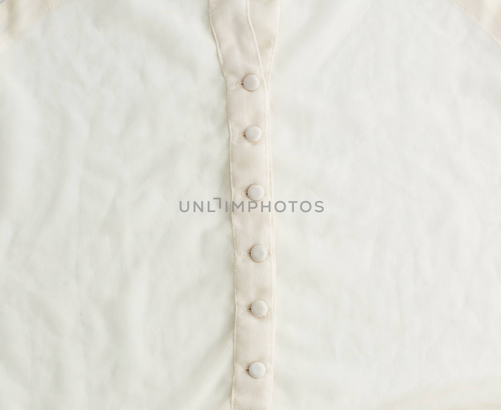 fragment of a silk beige blouse with buttons, full frame