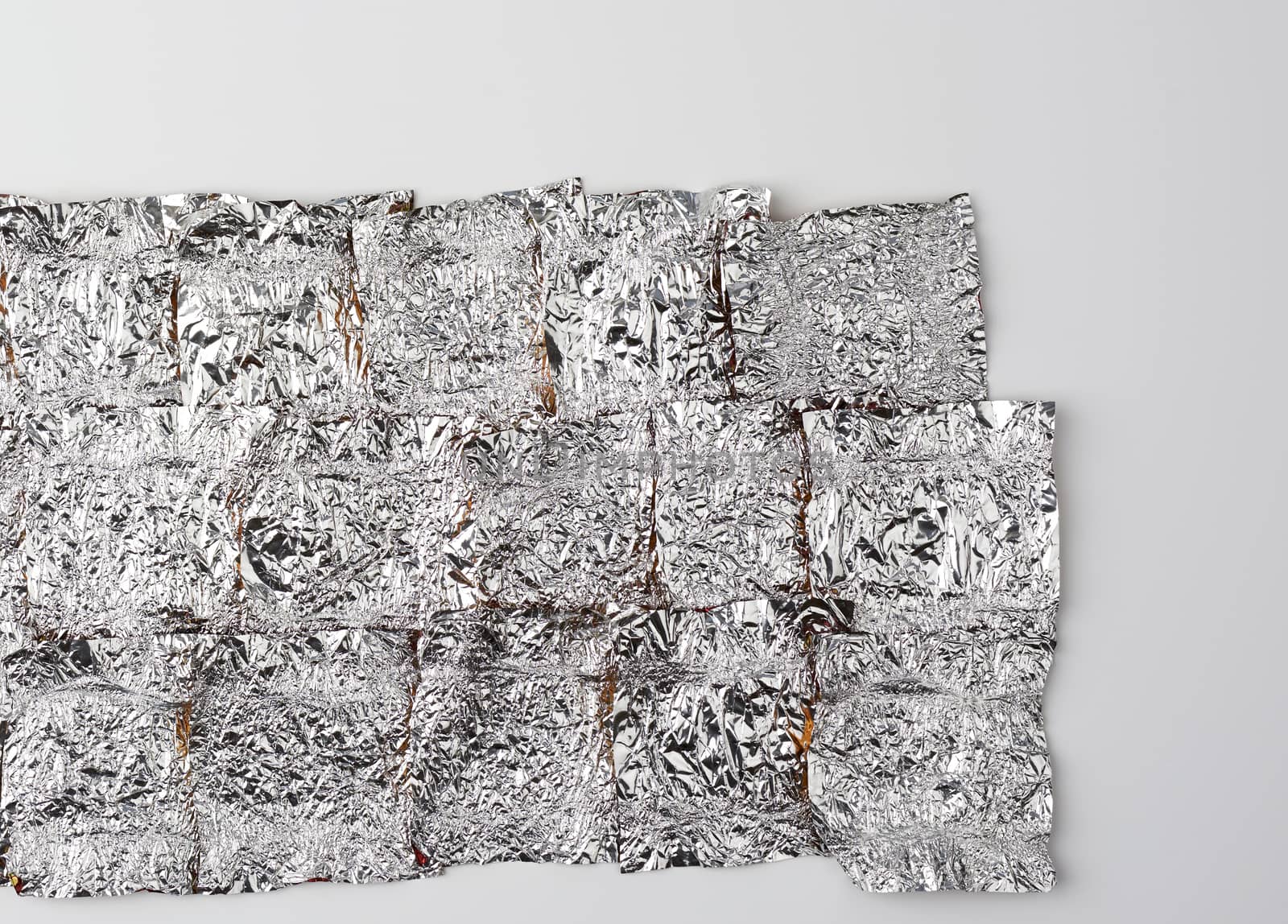 texture of crumpled candy wrappers, foil on a white background, close up