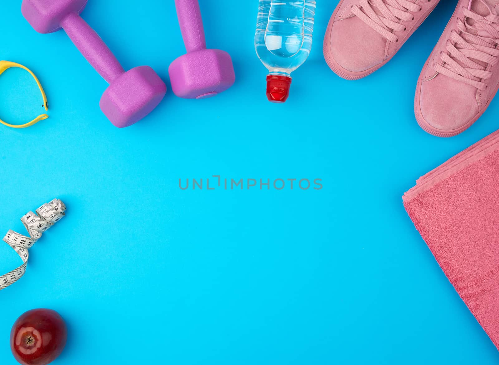 plastic purple dumbbells, sportswear, water, pink sneakers on a blue background, fitness kit, flat lay, copy space