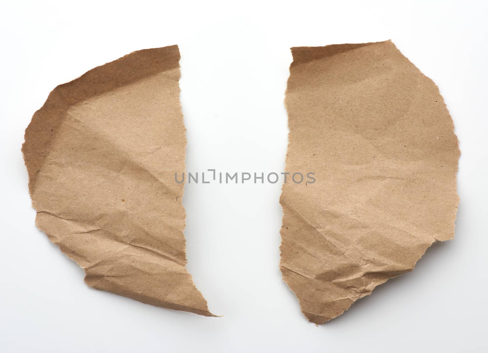 fragment of crumpled blank sheet of brown wrapping kraft paper with torn edges, vintage texture for the designer, white background