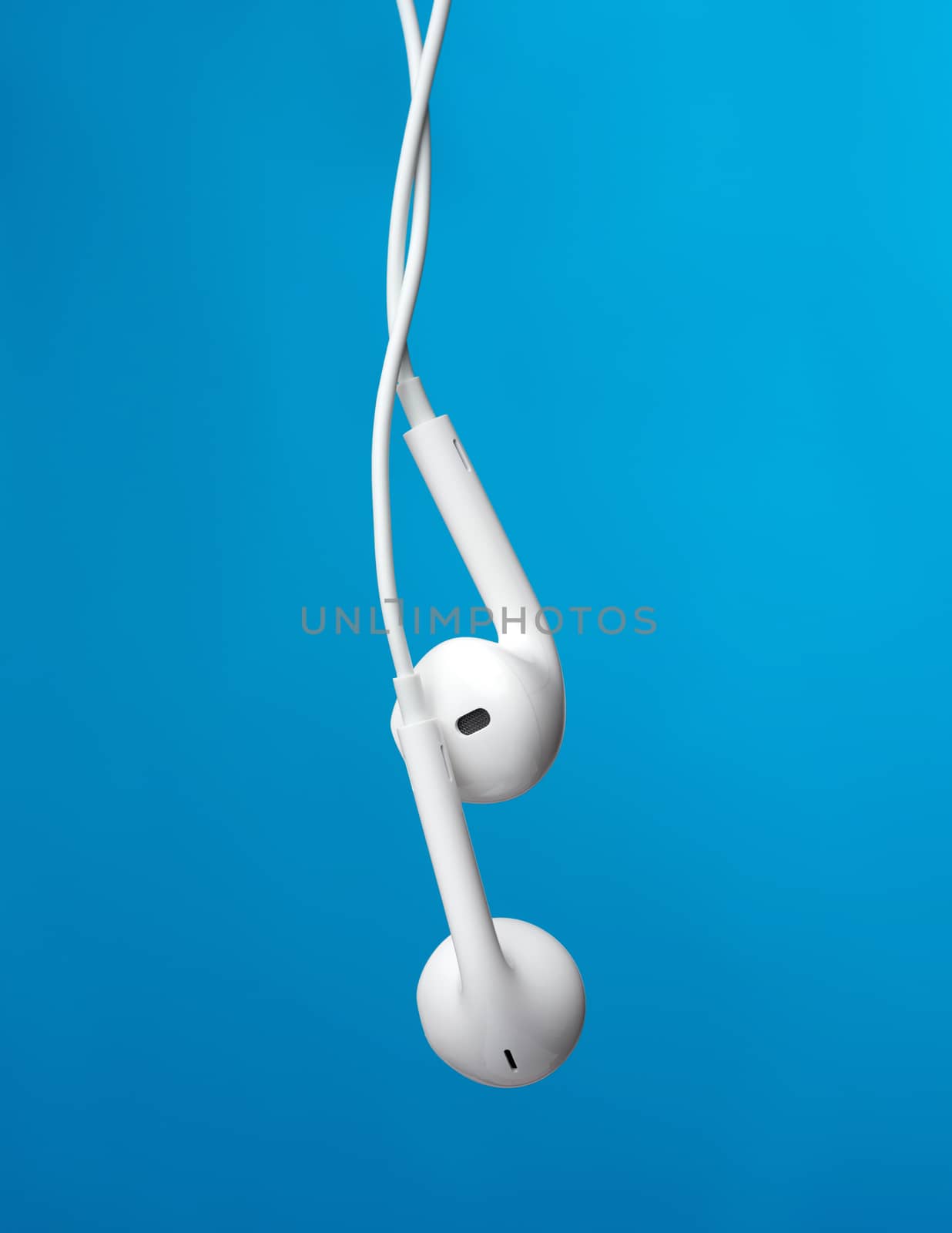 hanging headphones on a white cable, a modern gadget on a blue background, close up
