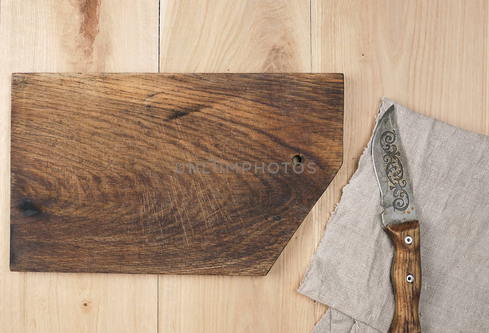 old empty wooden rectangular cutting board and knife, top view, beige wooden background 