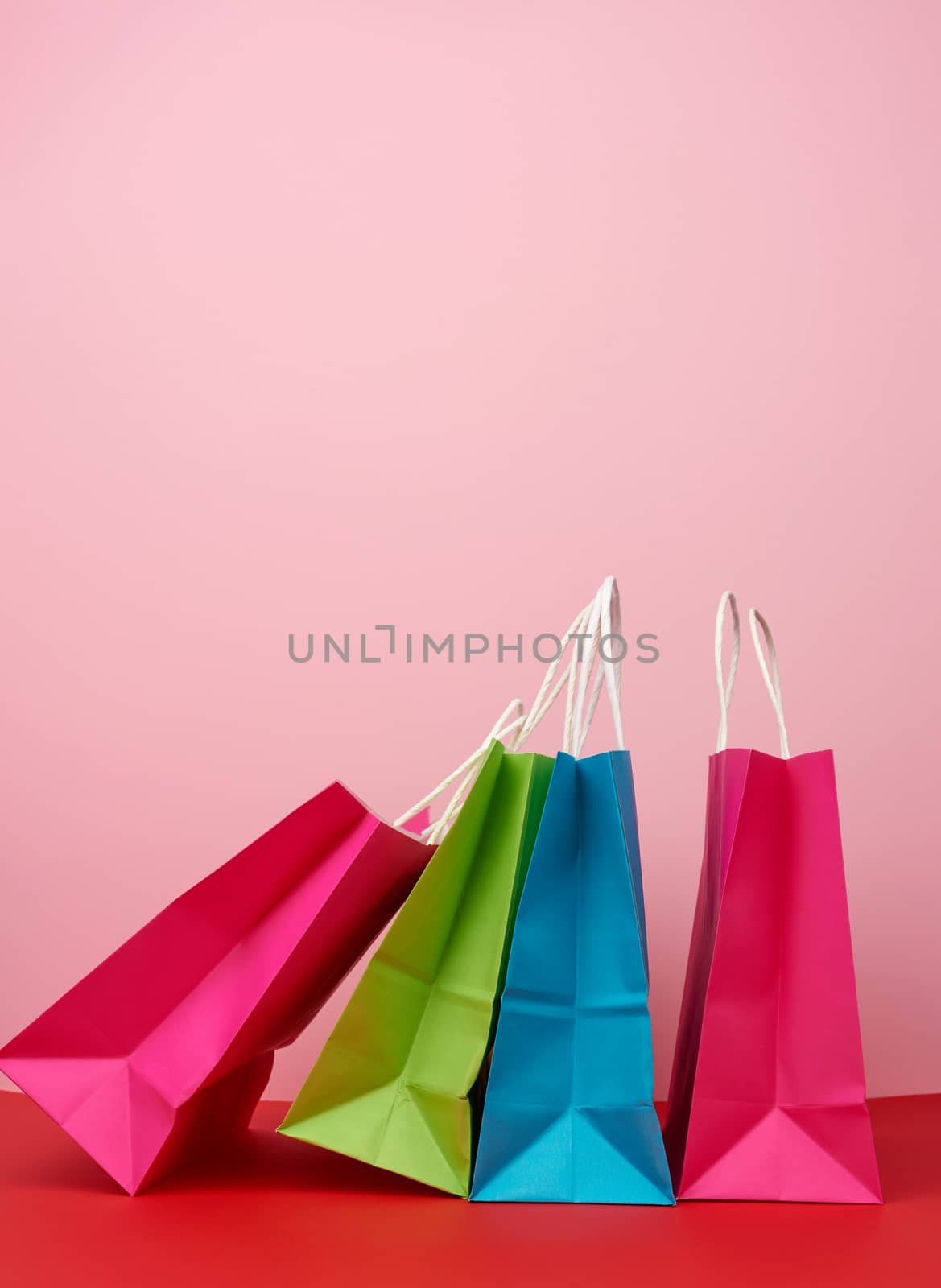 Four empty multicolored paper bags for shopping and gifts with w by ndanko