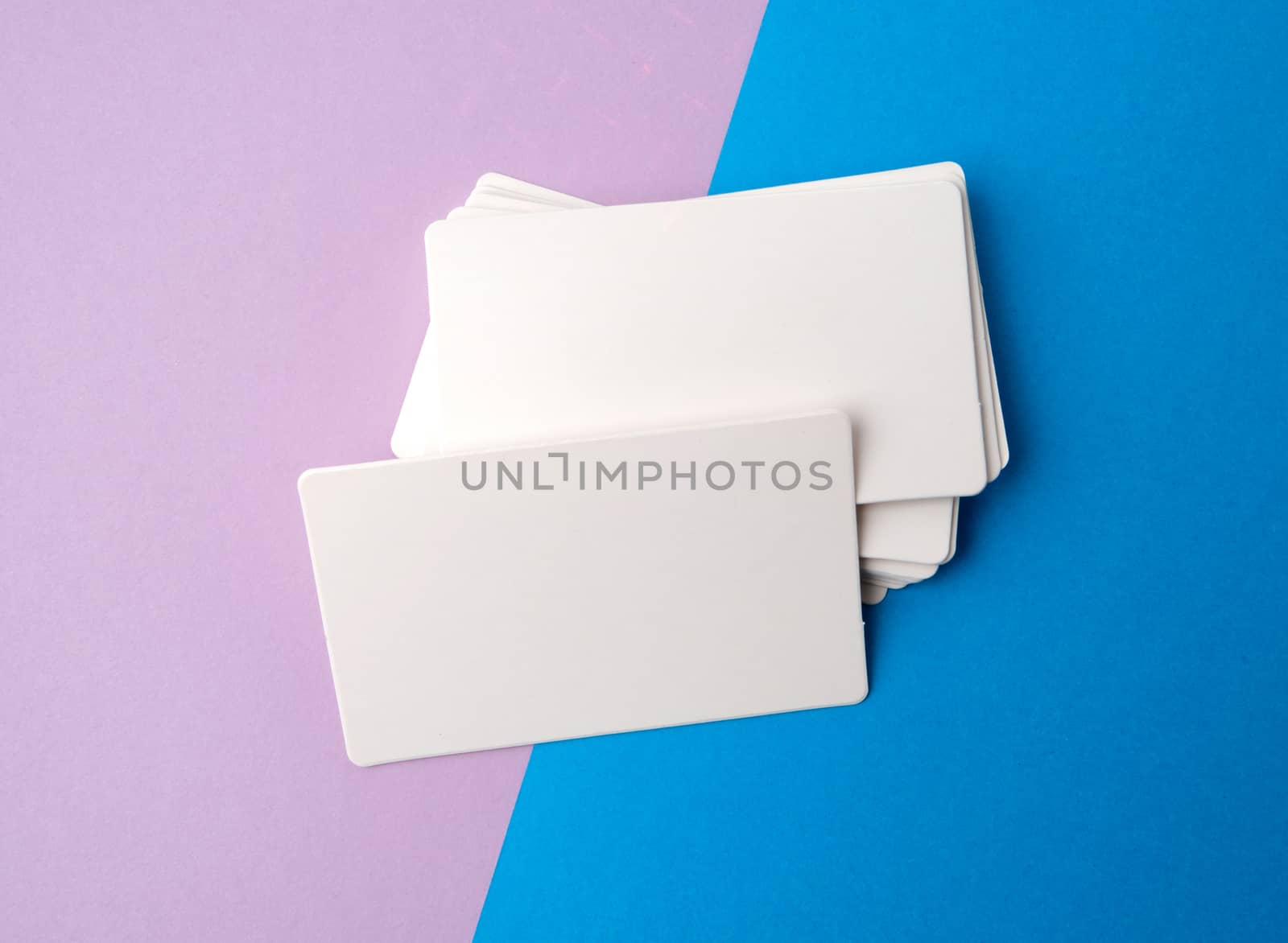 stack of rectangular white blank business cards on a blue background, backdrop for the designer