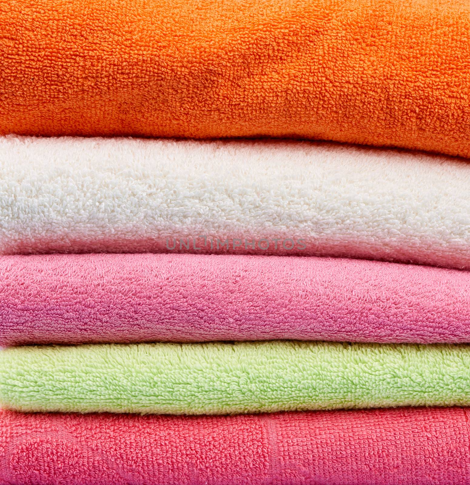 stack of colored cotton terry folded towels, close up