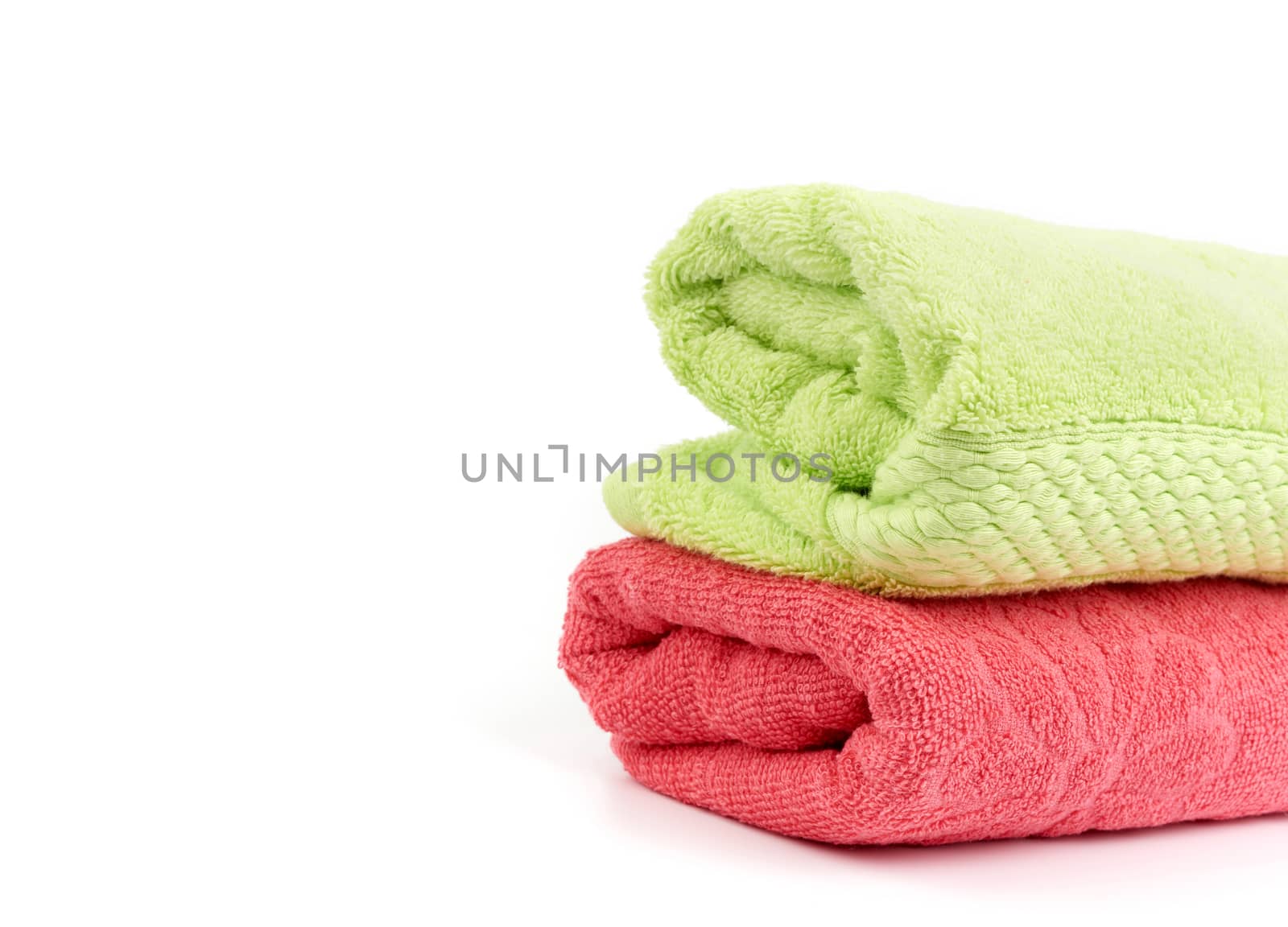 stack of colored cotton terry folded towels on a white background, copy space