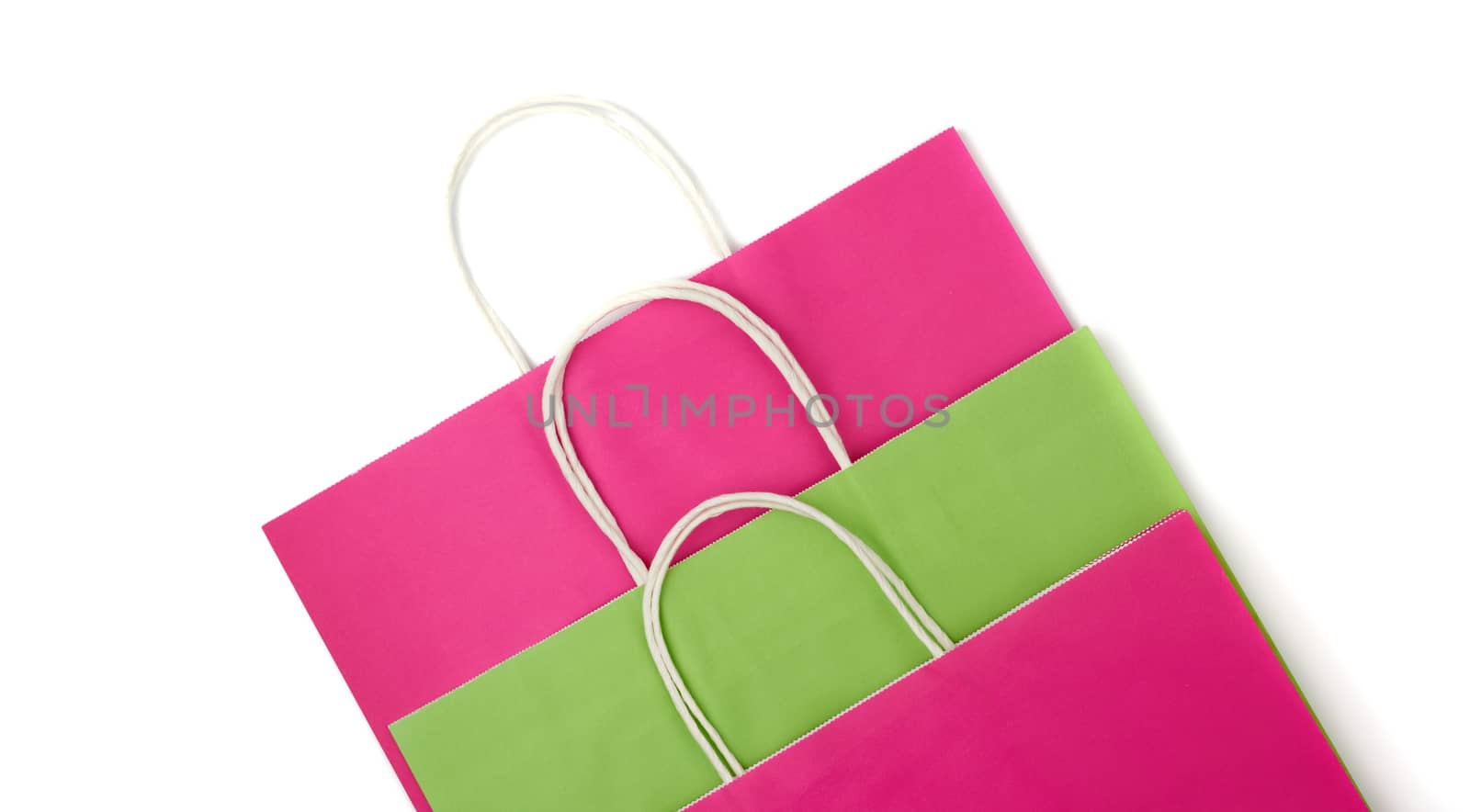 paper pink and green bags with white handles for shopping and gifts isolated on white background, flat lay