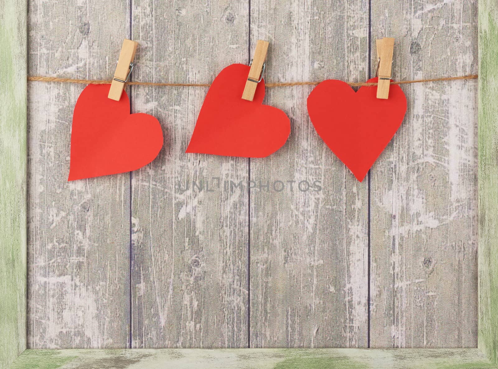 carved red paper hearts hanging on a brown rope, gray background, valentines day card