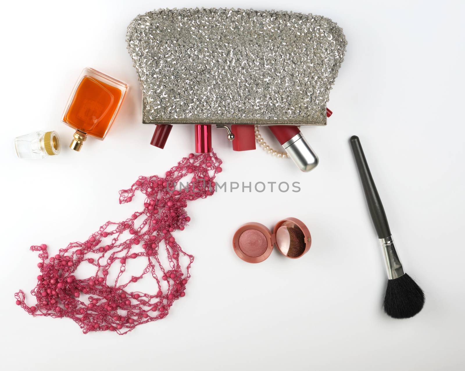 open silver cosmetic bag and women's cosmetics and perfumes, red lipstick, perfume on a white background