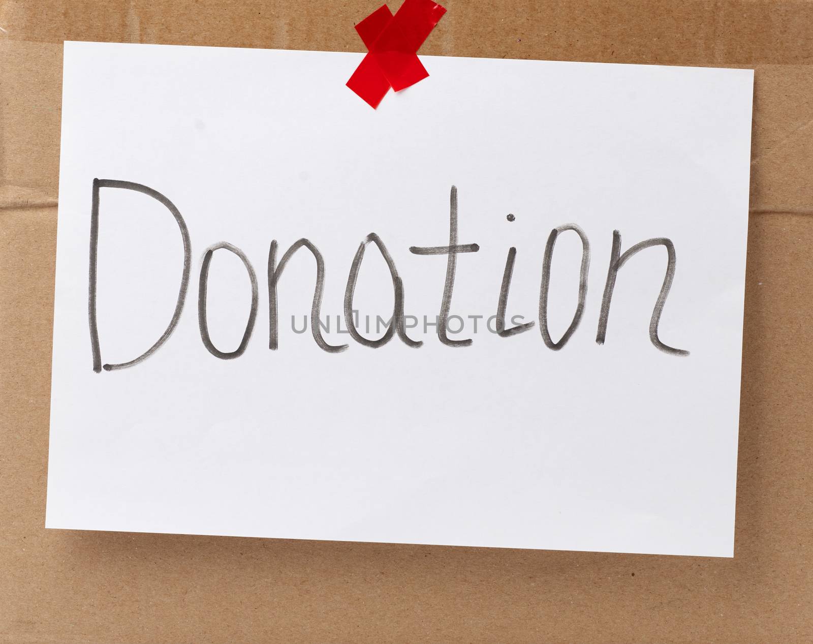 inscription donation on a white sheet and glued brown cardboard paper, concept of volunteering and promotion