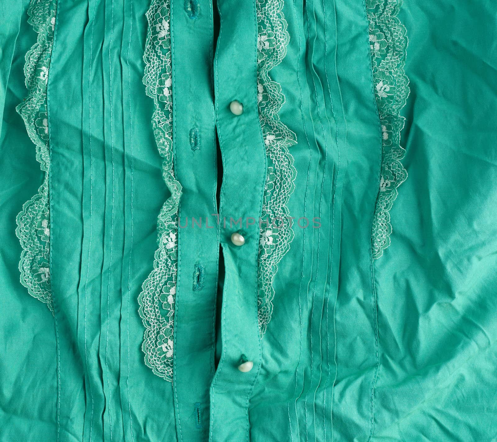 fragment of a female green shirt with lace and buttons, full frame