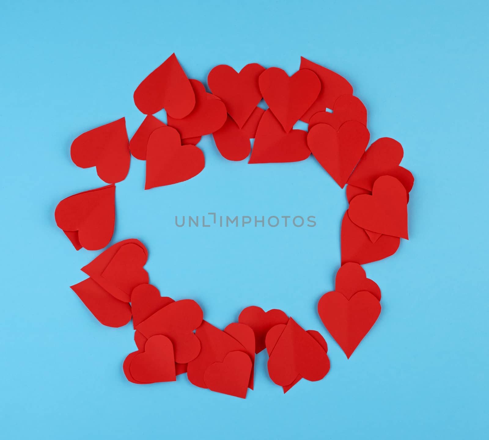 hearts cut out of red paper on a blue background, festive backdrop for Valentine's Day, copy space