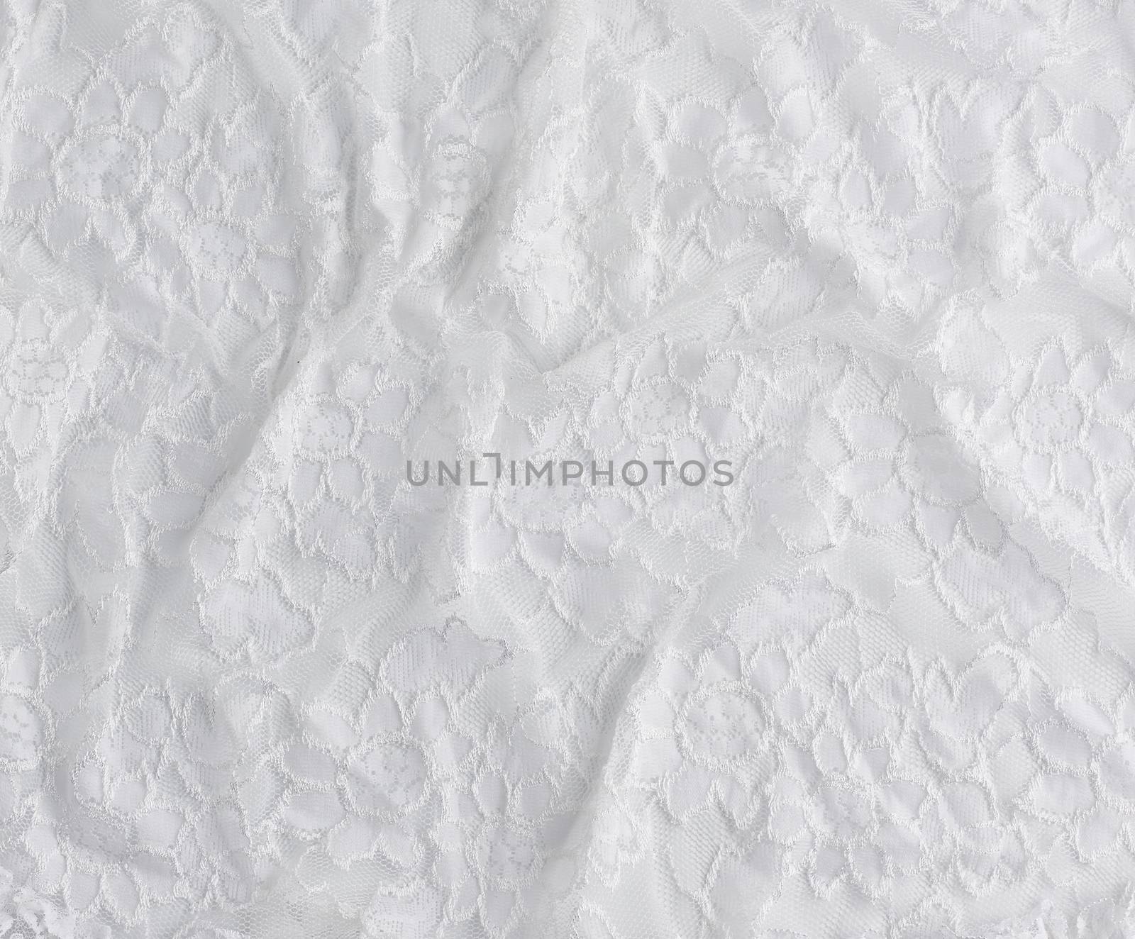 texture of crumpled white synthetic fabric guipure for sewing clothes on a white background, full frame