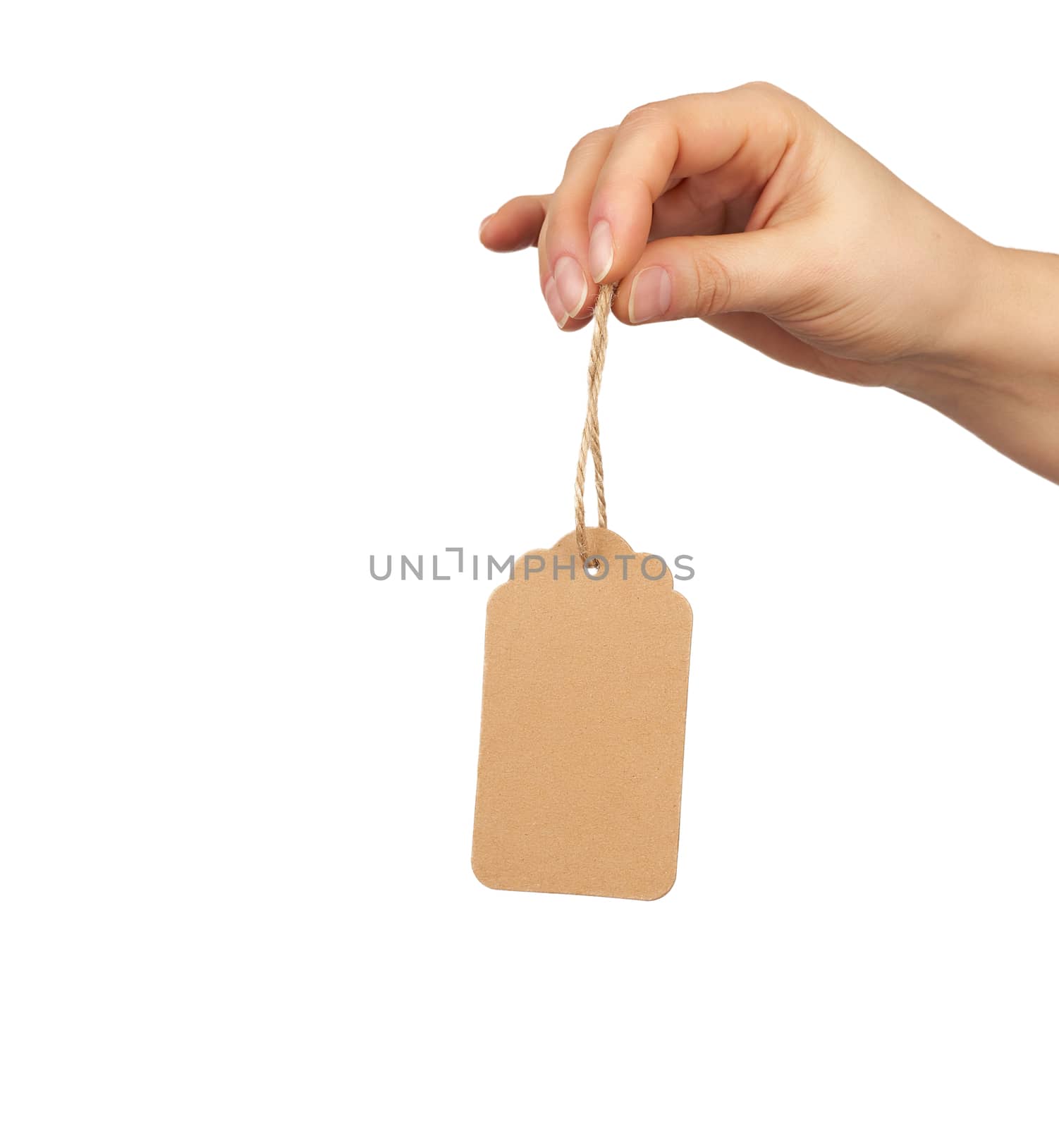 female hand holds a cardboard price tag from brown craft paper on a rope, subject is isolated on a white background