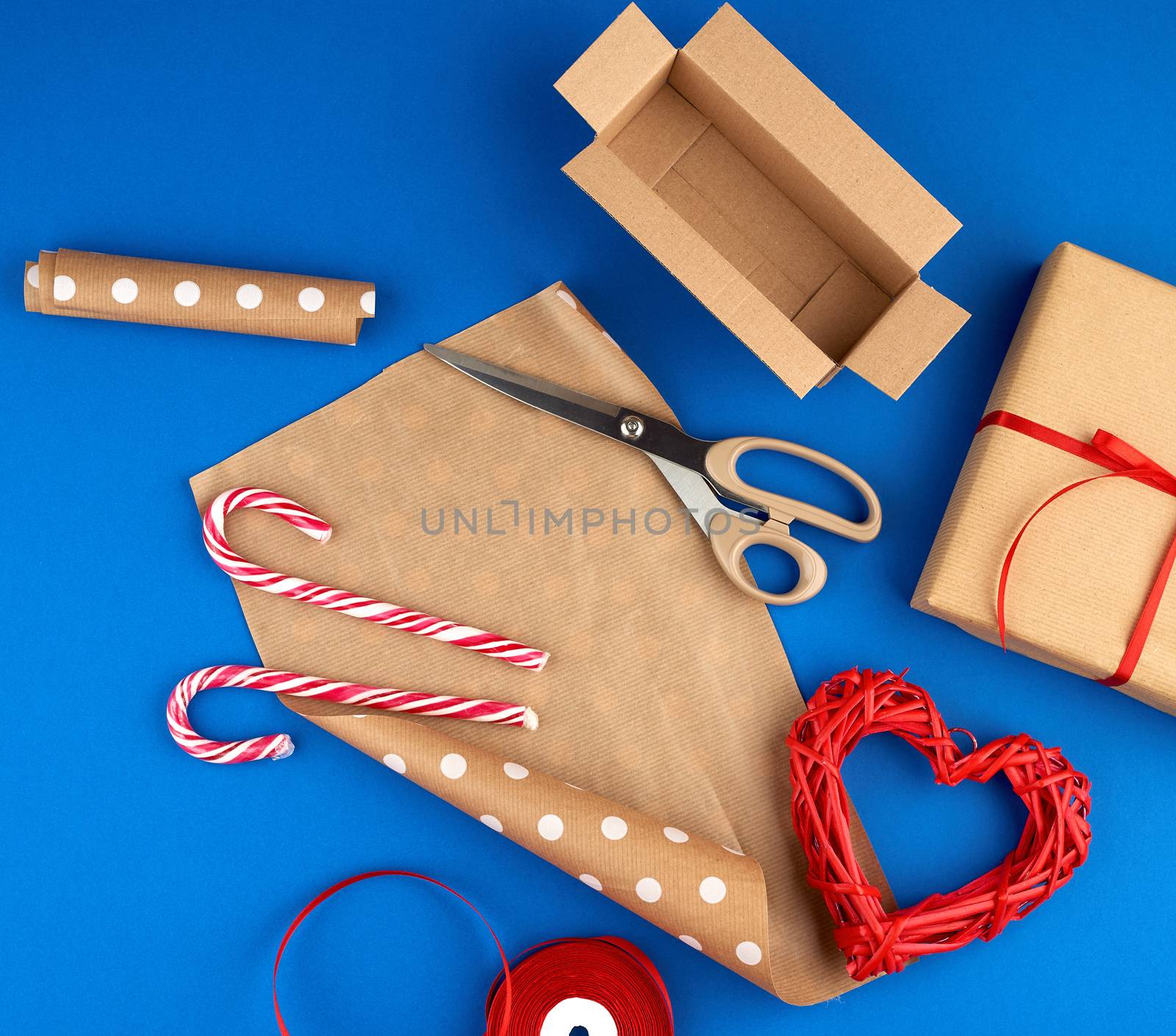brown kraft paper, packed gift bags and tied with a red ribbon, red heart, set of items for making gifts with your own hands. Gift wrapping. Package design