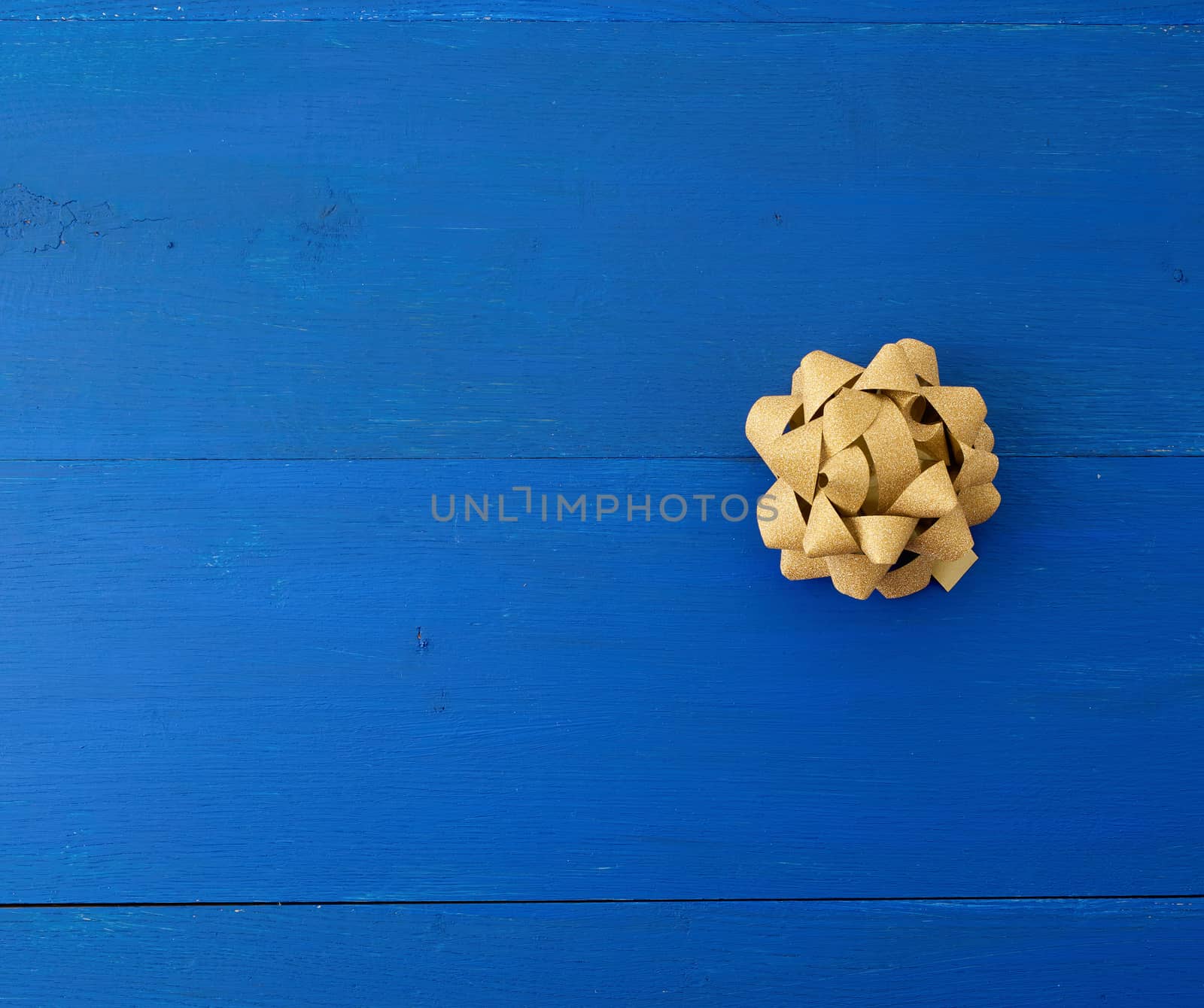golden bow on a blue wooden background from boards,  place for an inscription