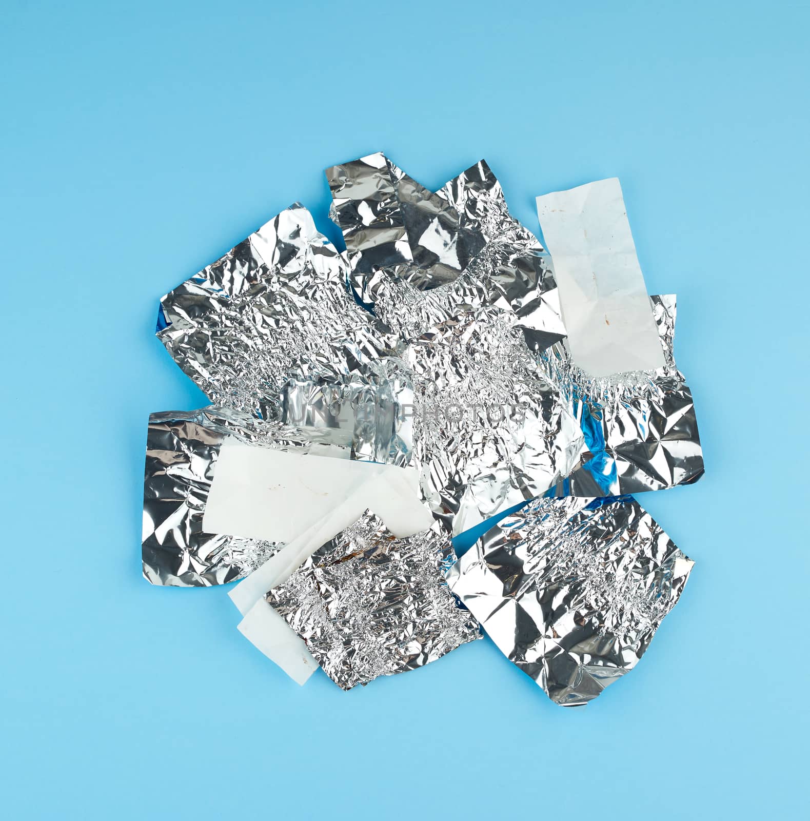 various crumpled white paper and foil used candy wrappers on a b by ndanko