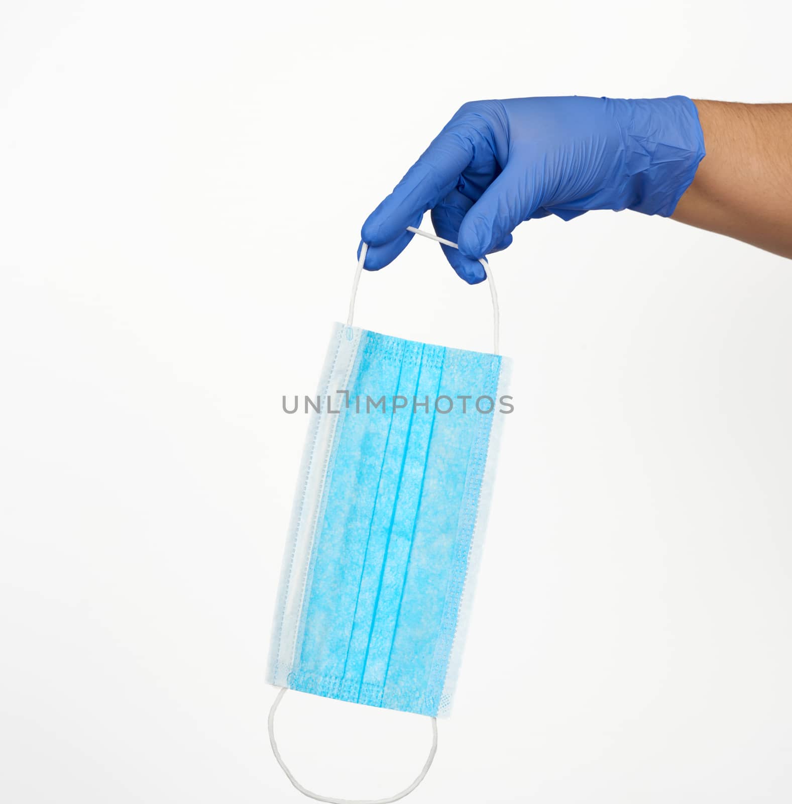 hand holds a medical face mask against viruses and bacteria on a white background, protective medical tool