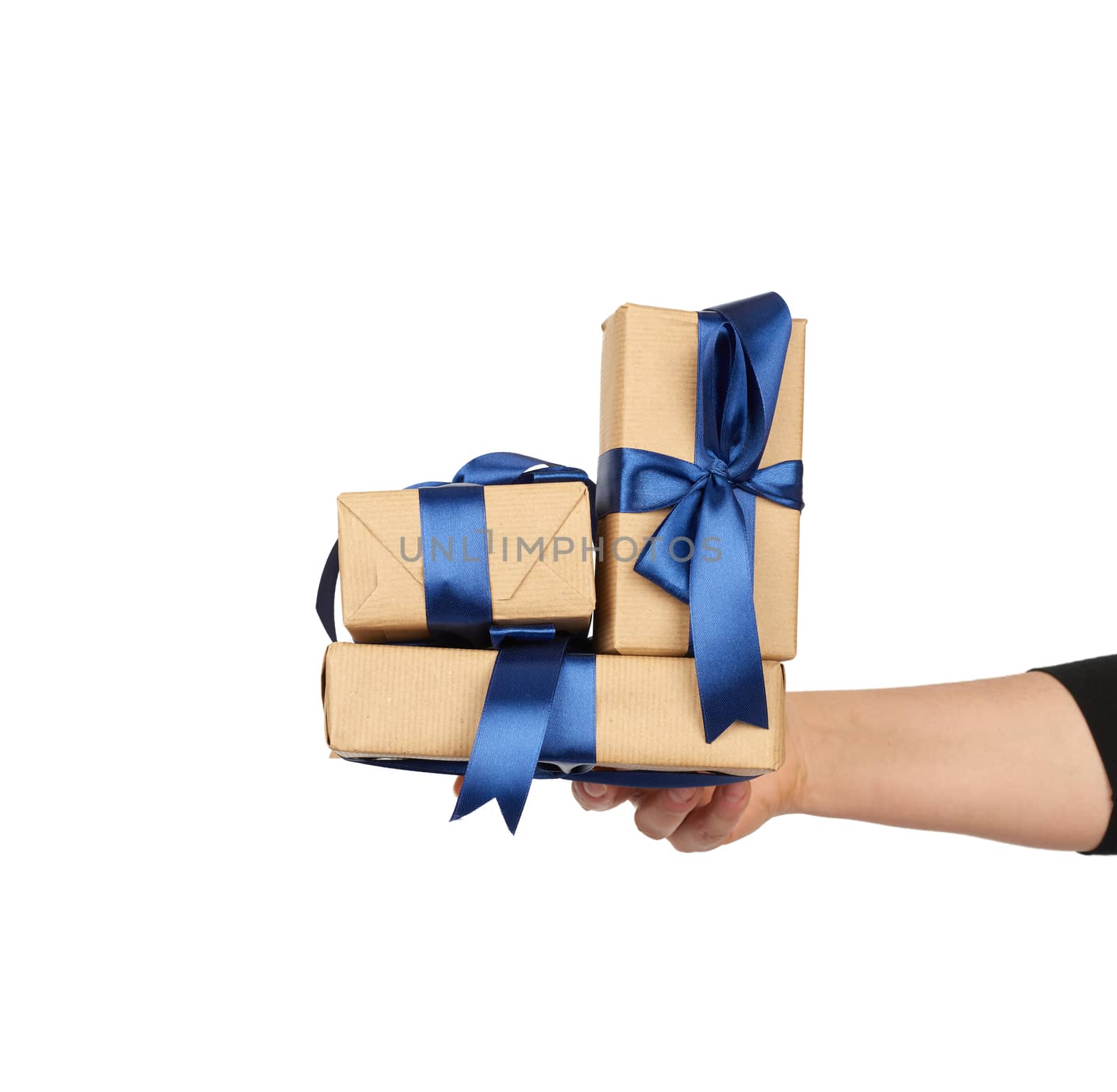 hand holds a stack of wrapped gifts in brown craft paper with tied silk bows, subject is isolated on a white background