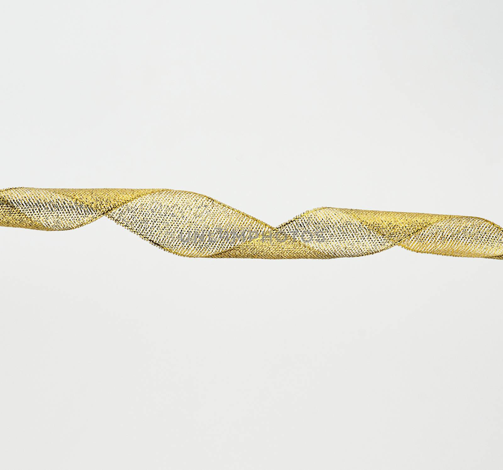 twisted golden silk decorative ribbon for packing gifts on a white background, close up