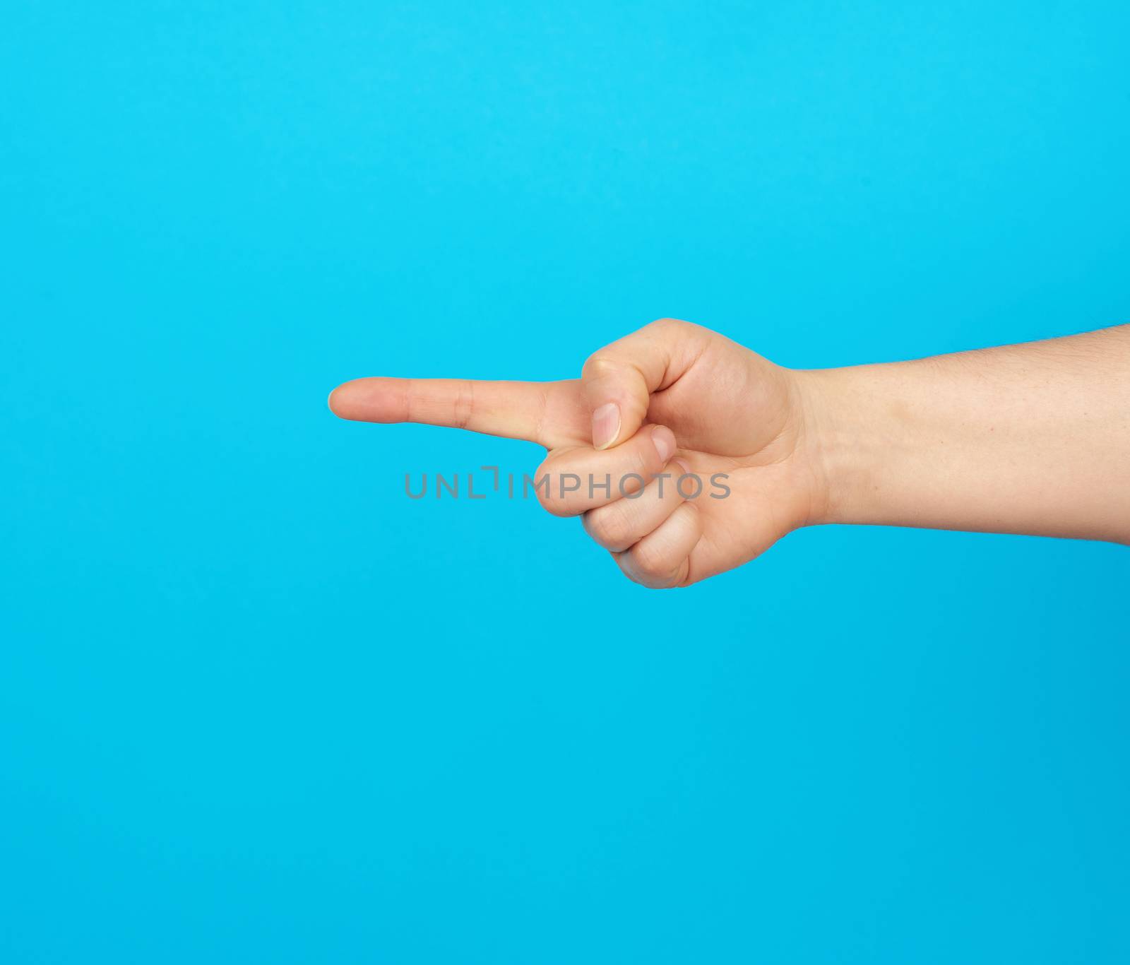 hand shows forefinger gesture on a blue background, close up