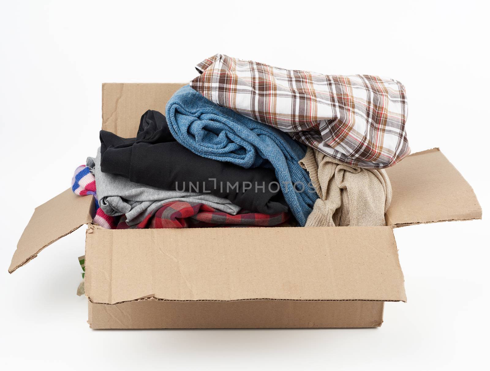 big brown cardboard box filled with various clothes on a white background, donation concept