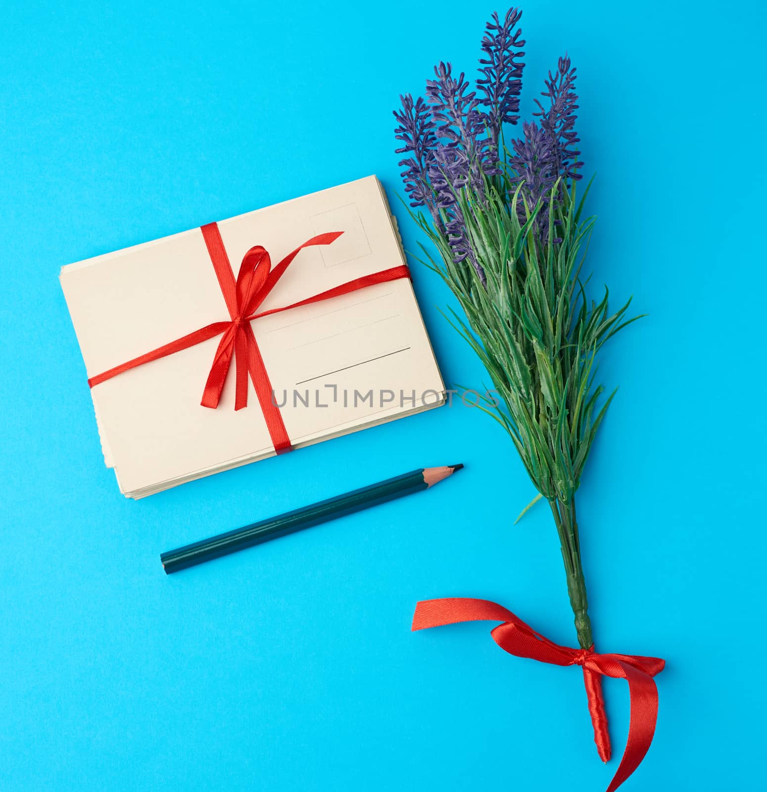 tied red silk ribbon rectangular vintage greeting card, blue background, top view
