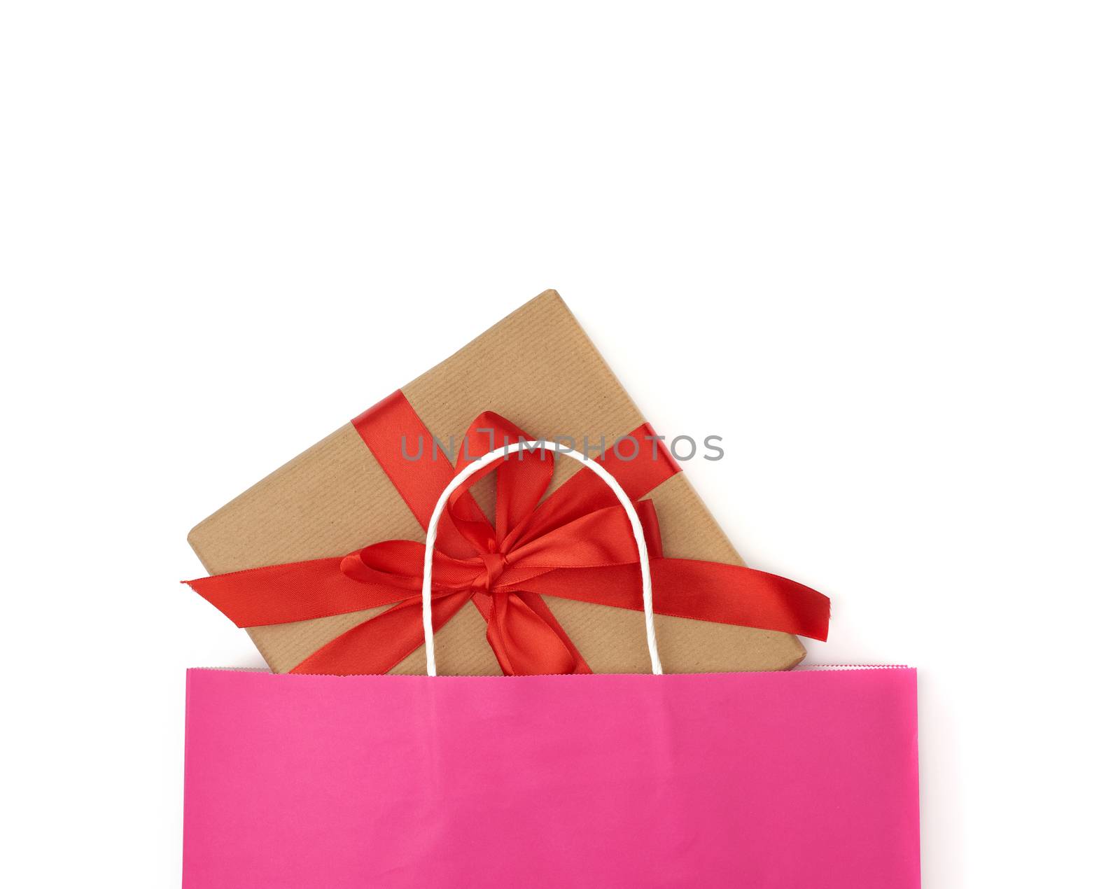 pink paper bag with a gift box on a white background, concept of shopping and giving a gift, flat lay