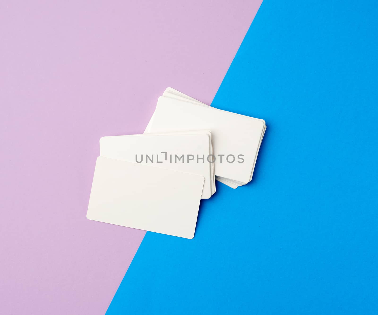 stack of rectangular white blank business cards on a blue background, backdrop for the designer