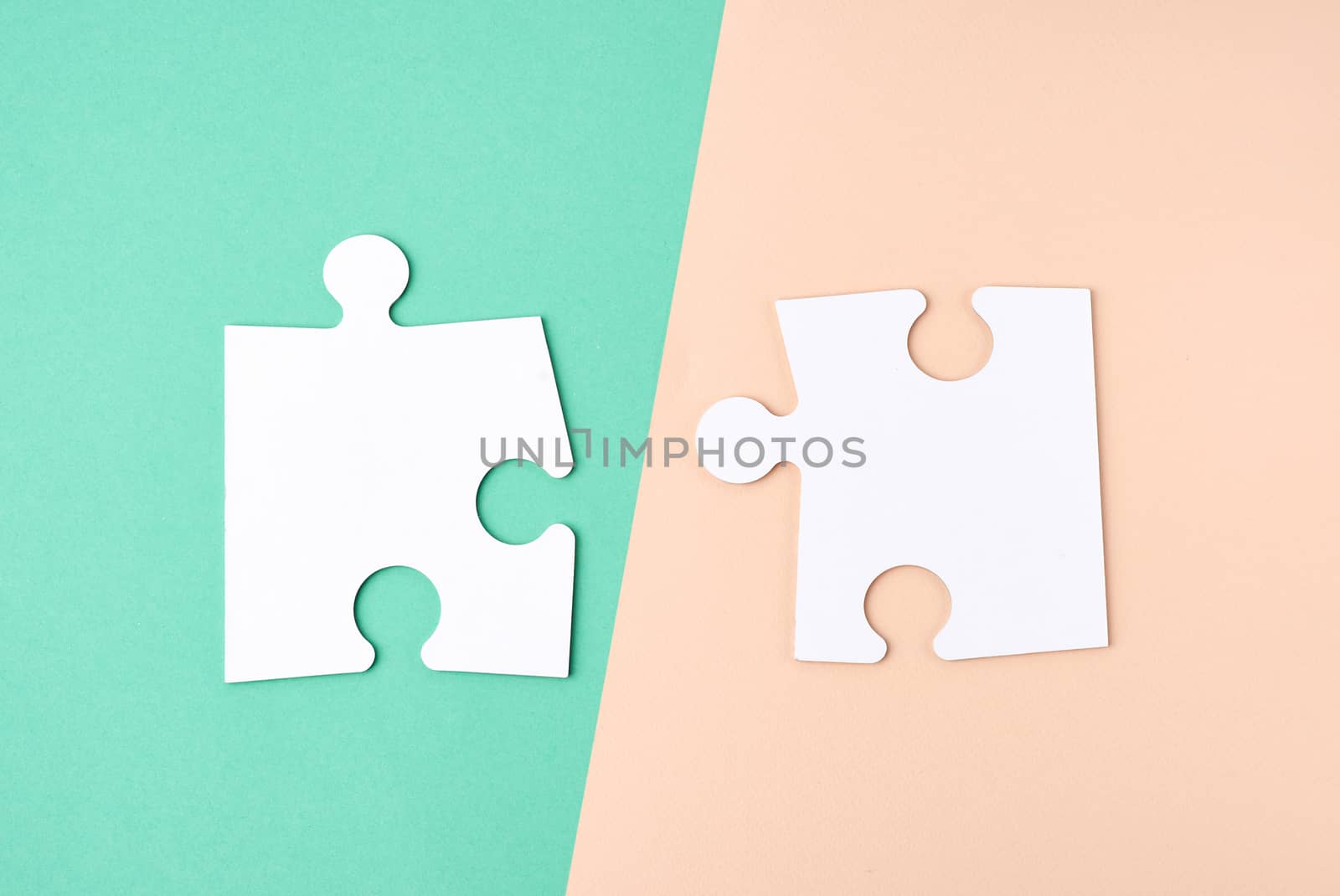 white large blank paper puzzles on a beige green background, top view, copy space
