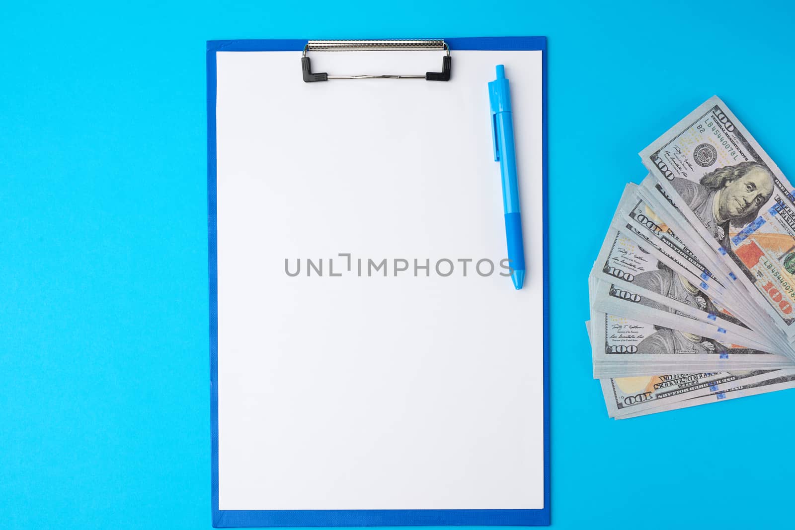 blue paper holder with white blank sheets and a stack of paper american dollars, concept of planning and conservation, cash investment