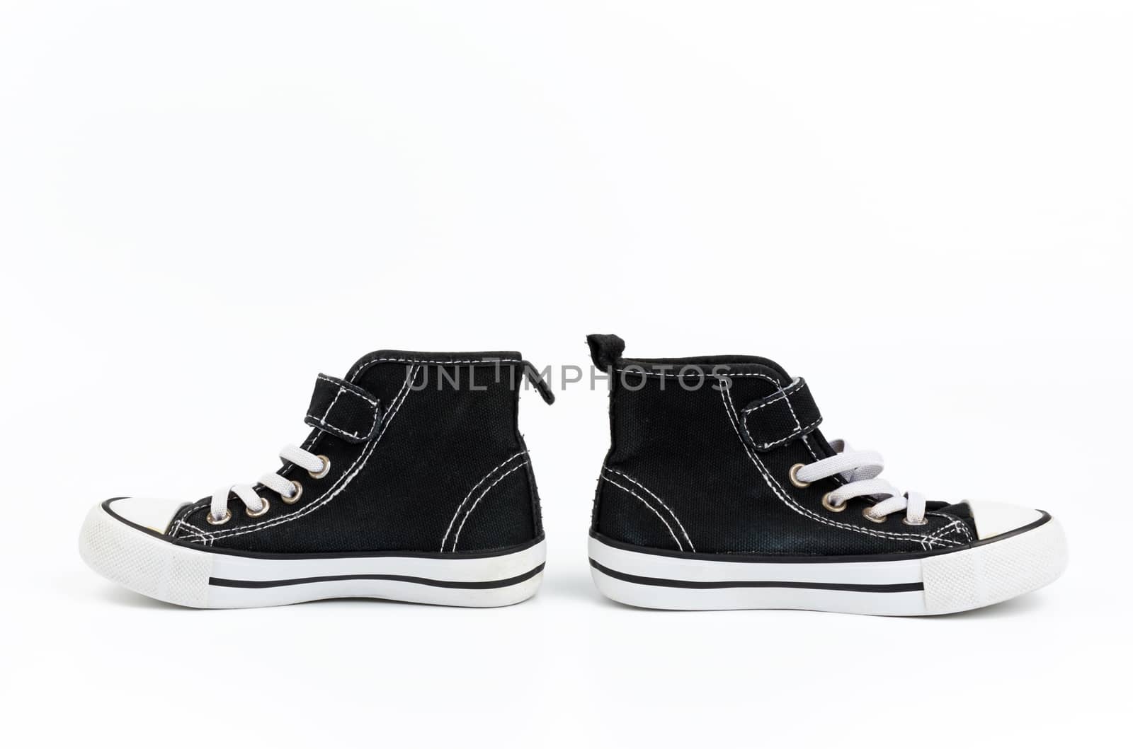 black textile sneakers with white tied shoelaces on a white background, pair shoes stand sideways