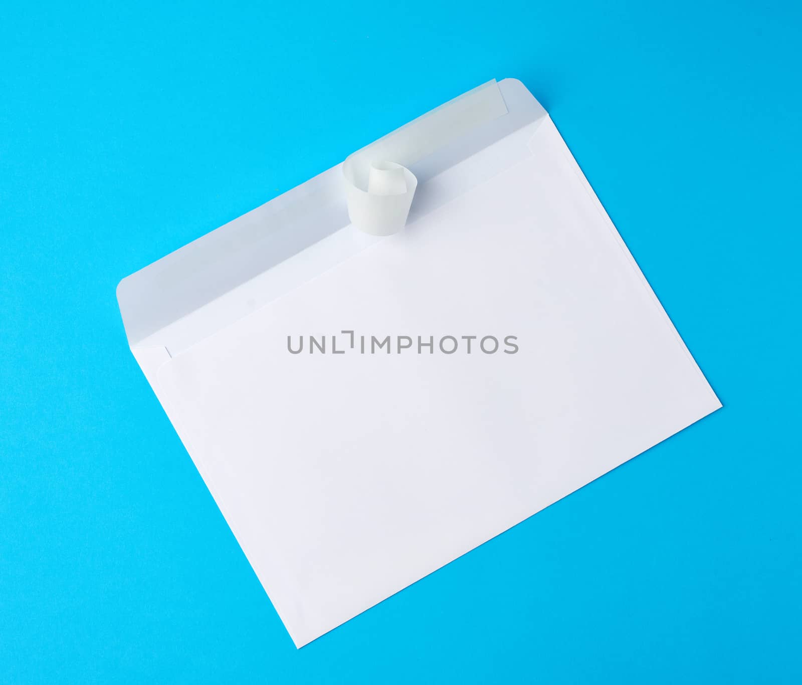 white rectangular blank paper envelope on a blue background, flat lay