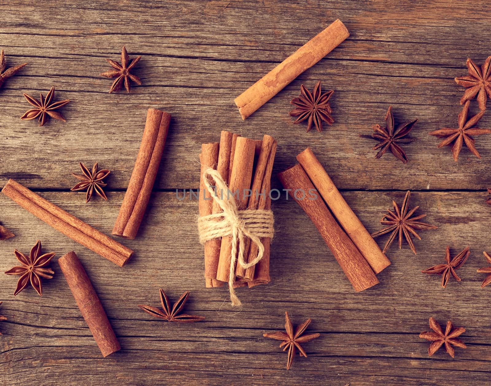 brown cinnamon sticks tied in a bun on a gray wooden background, tasty and fragrant spice, top view