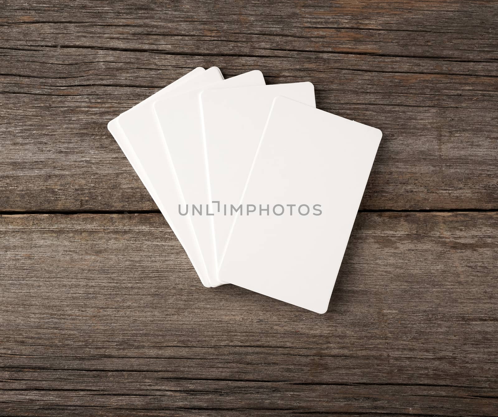stack of rectangular white blank business cards on a gray wooden background, backdrop for the designer, copy space