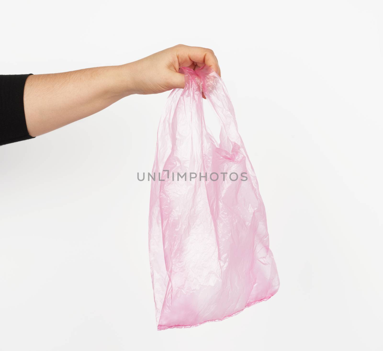 hand holds an empty pink plastic bag on a white background, concept of rejection of plastic and the transition to eco-packaging