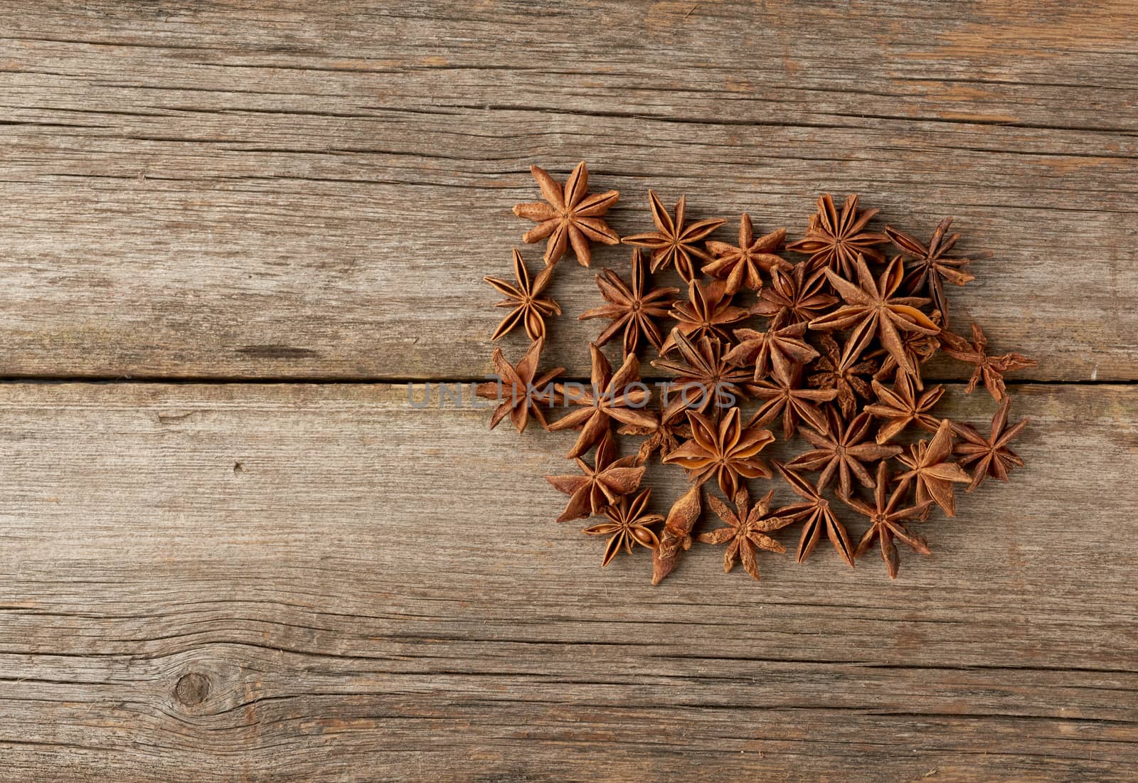fragrant anise star anise on a gray wooden background from boards, top view, copy space
