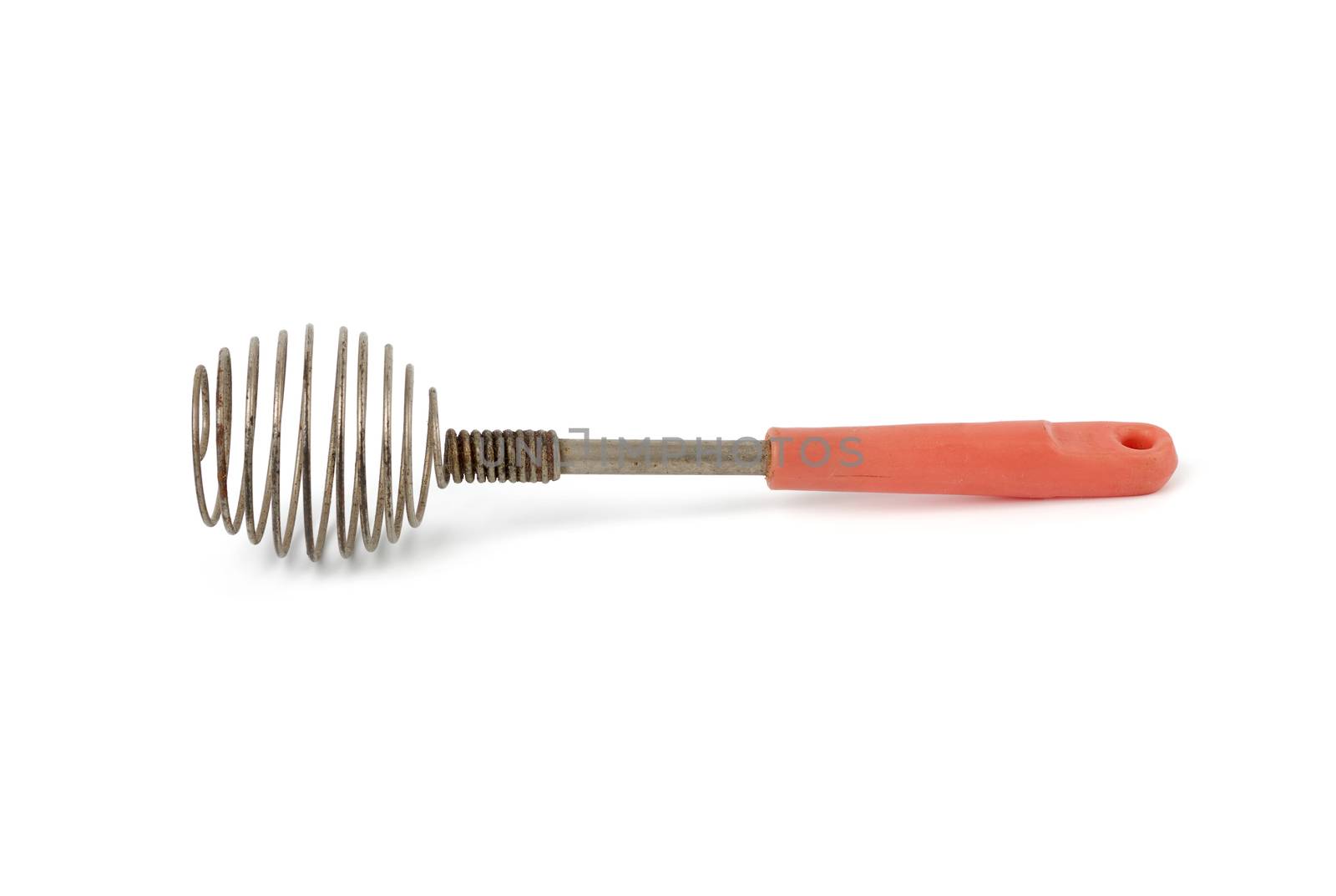 very old kitchen utensil for beating eggs, liquids with a handle isolated on a white background