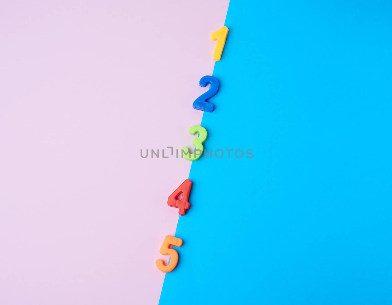 multi-colored plastic children`s figures on a colored background, flat lay, copy space