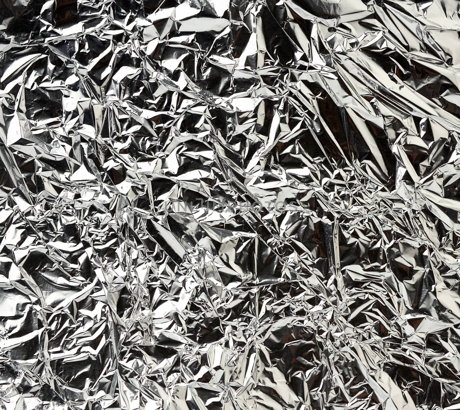 texture of shiny crumpled piece of gray foil, packaging material for food and objects, full frame