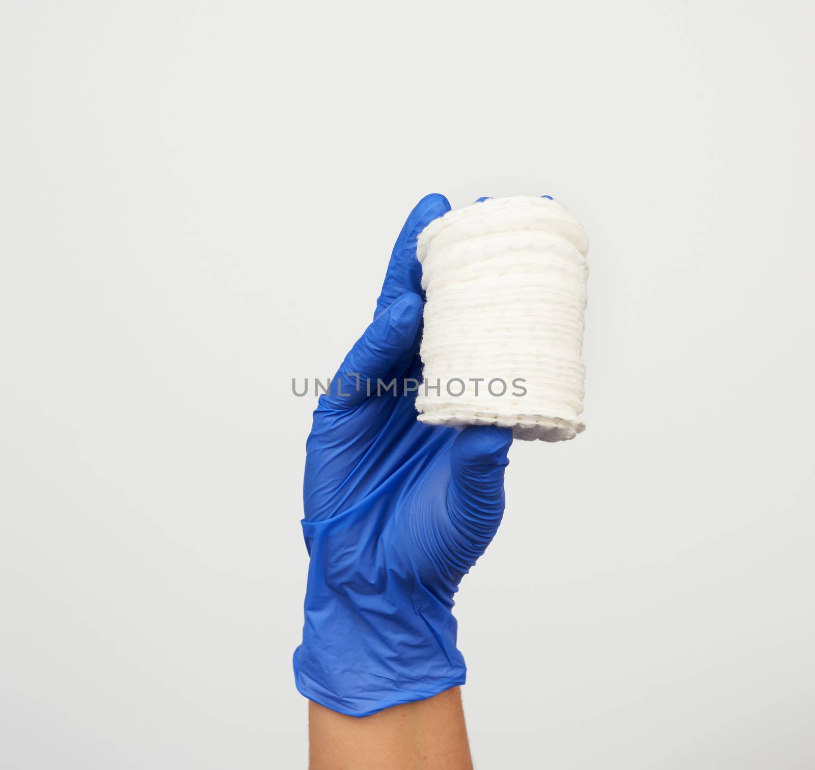 hand hold stack of white cotton round discs for cosmetic procedures on a white background