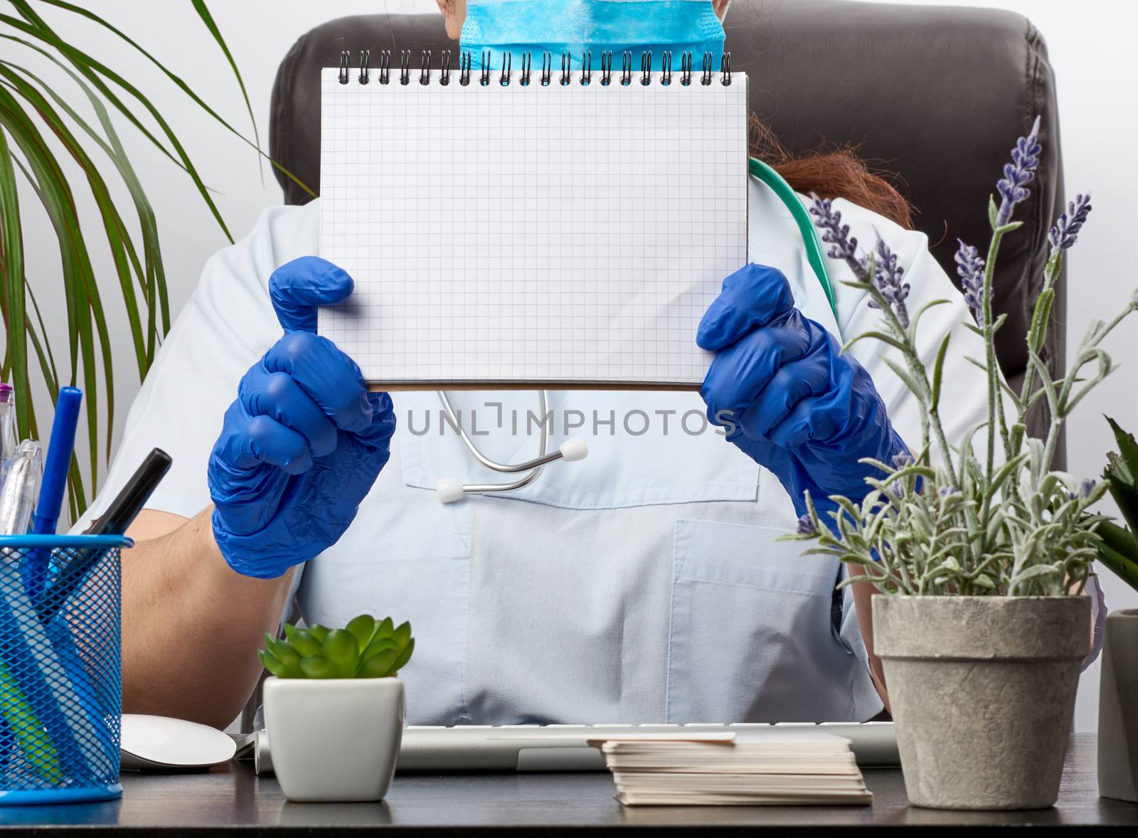 medic woman in white coat, blue latex gloves holding an open notebook with blank white sheets, white background, place for text