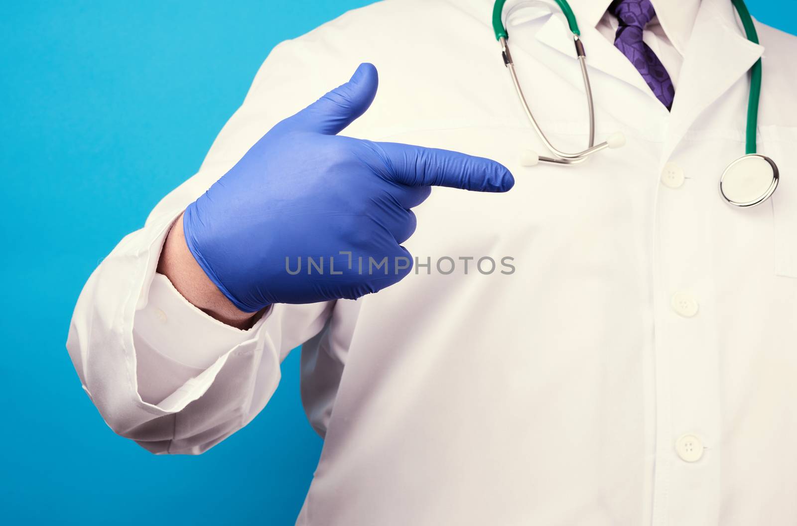 medic man in white coat with buttons, on hands wearing blue sterile gloves, showing hand gesture indicating the subject, blue background