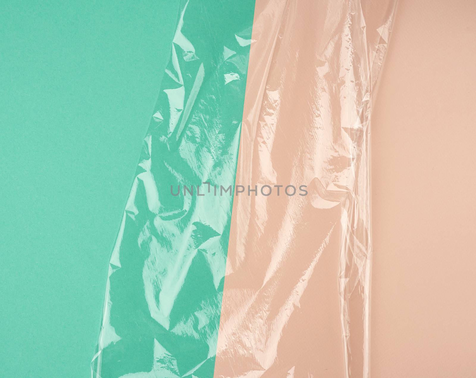 texture of a transparent stretching plastic film for packaging products on a green beige background, full frame,copy space