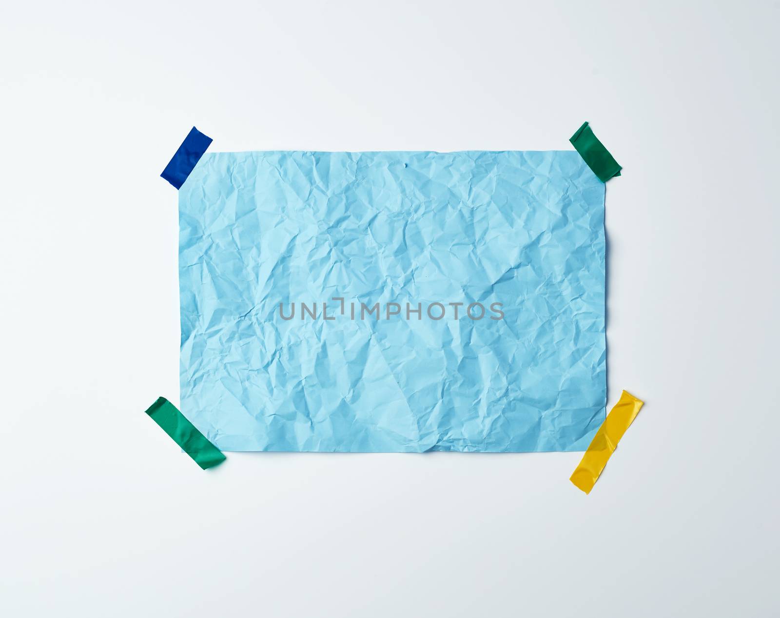 blue crumpled sheet of paper glued with adhesive tape on a white background, place for text