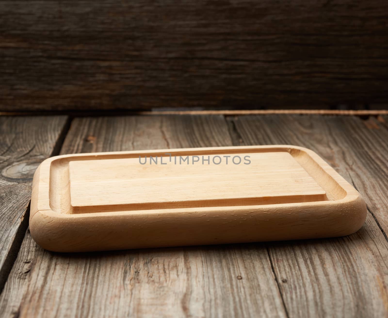 light beige rectangular empty cutting kitchen board on a wooden background from old boards, top view