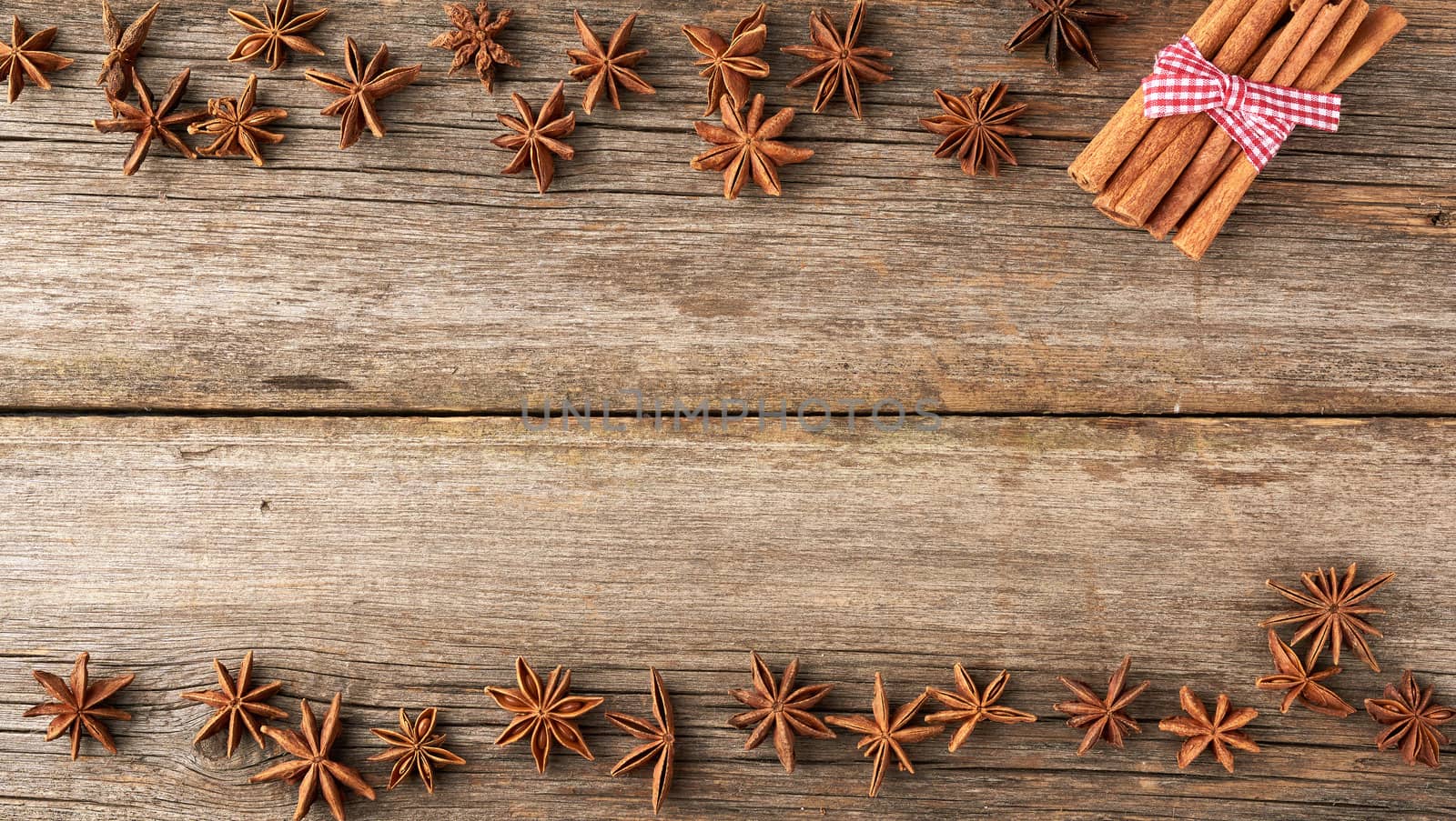 brown cinnamon sticks and dry star anise on a gray wooden background, tasty and fragrant spice, top view, copy space