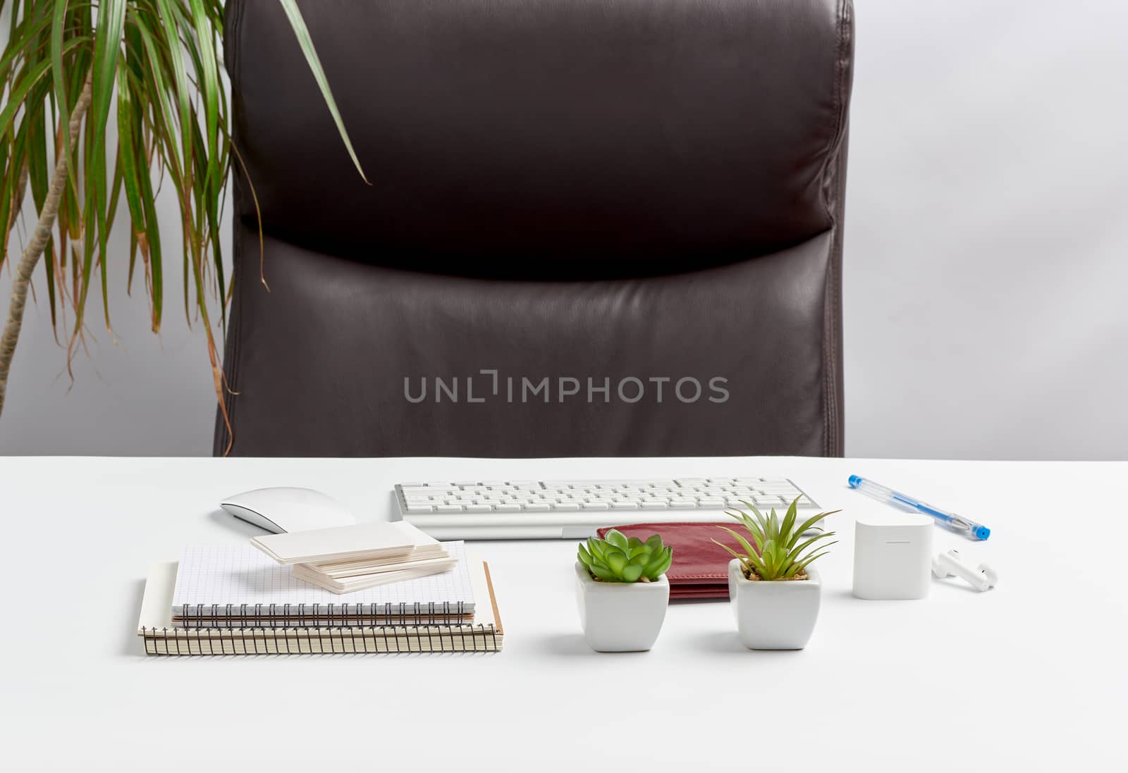 White table with stationery, wireless keyboard, mouse, workplace of a leader, businessman